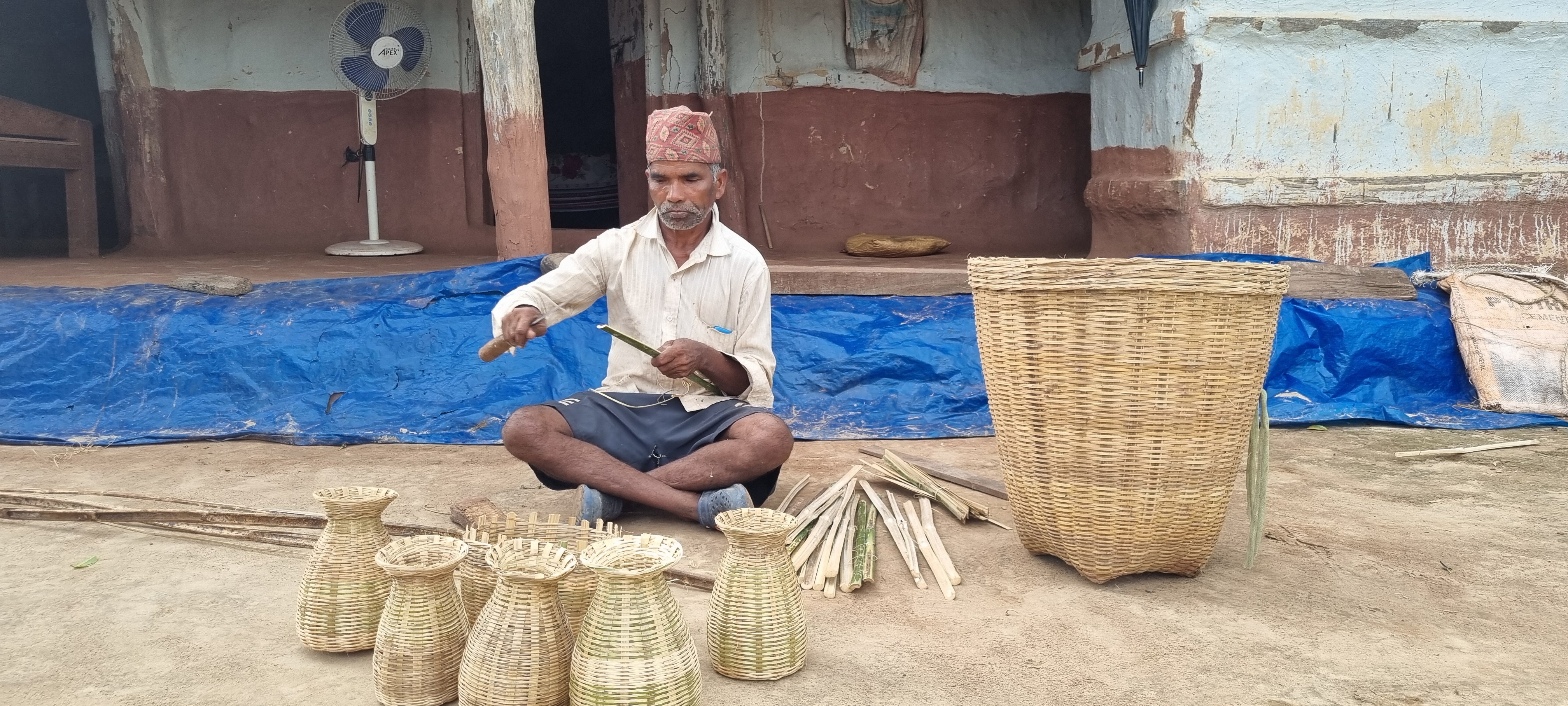 बाँसका सामग्री बनाउँदै मालुबेलाकै दानबहादुर लुहार।